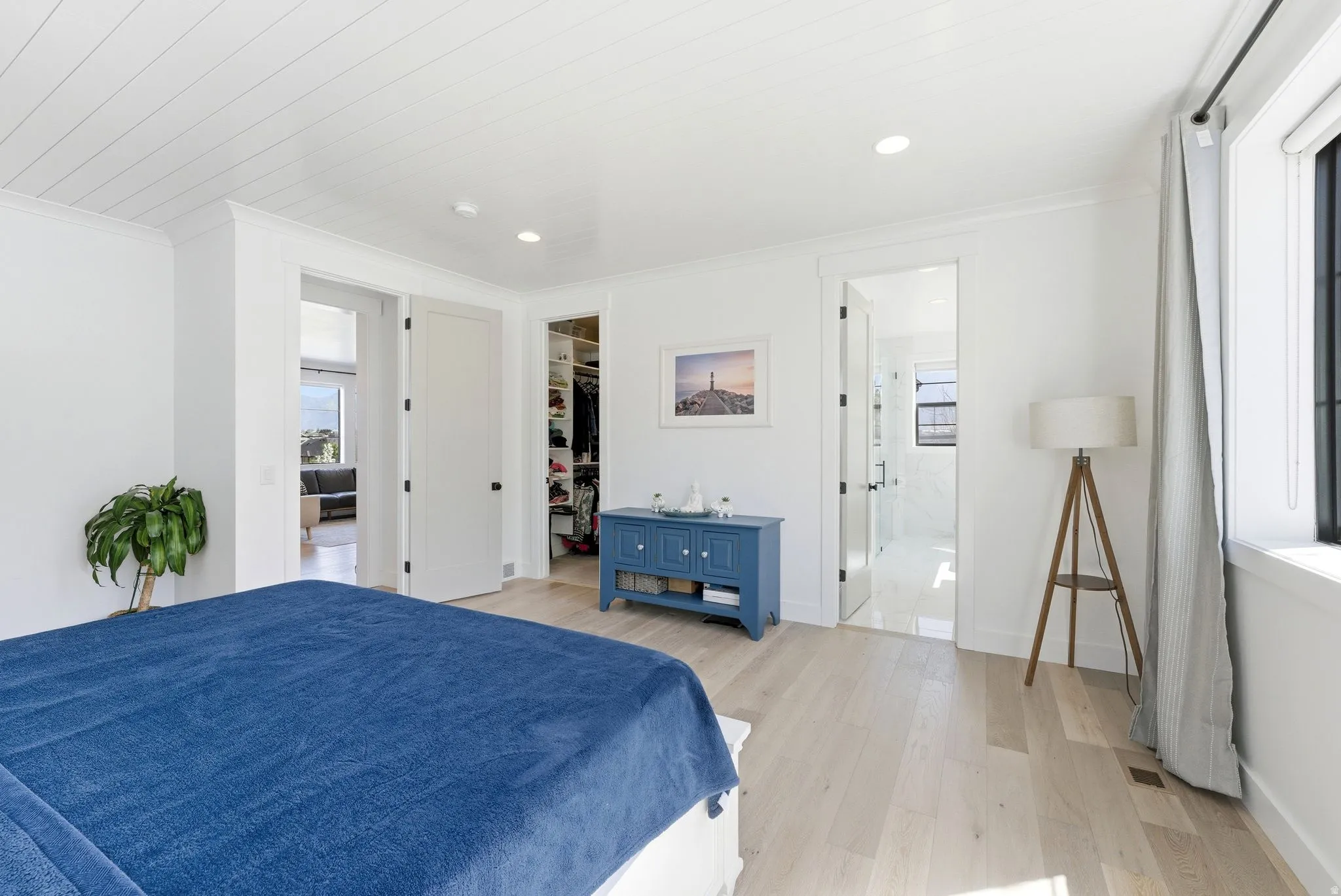 Primary Bedroom with light wood finished floors, a walk in closet, recessed lighting, and ornamental molding