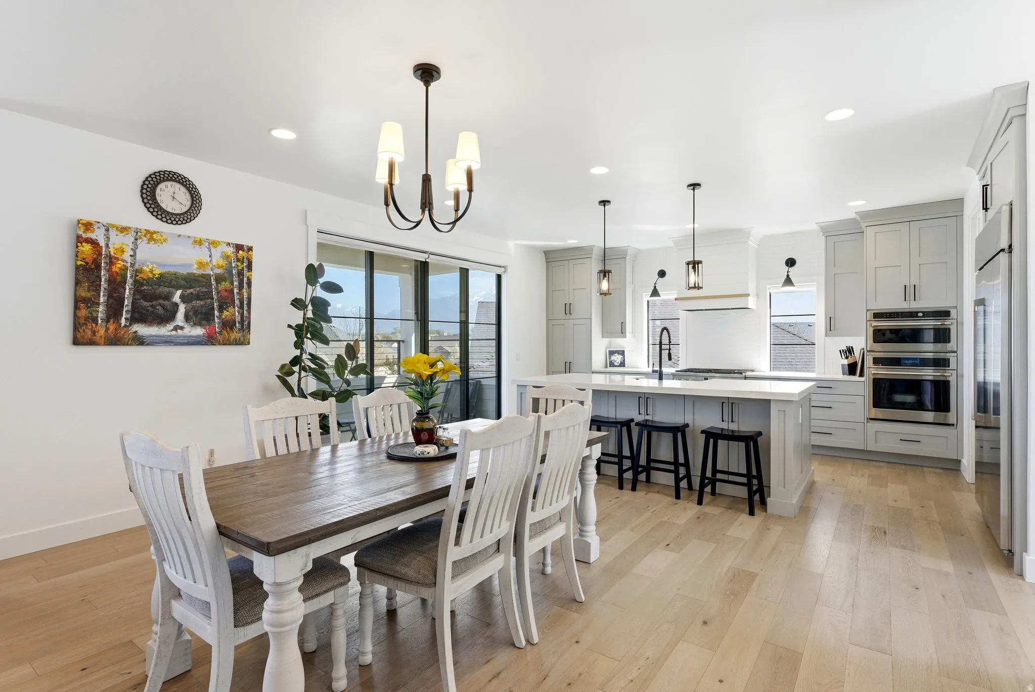 Dining space with light wood finished floors, healthy amount of natural light, and a chandelier