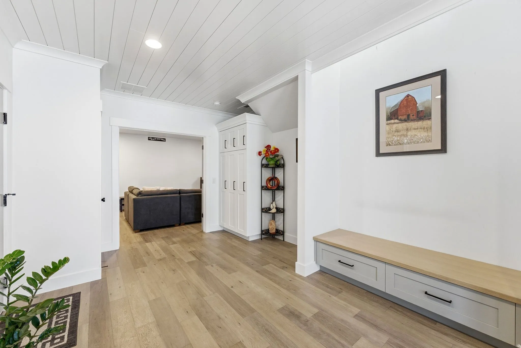 Corridor featuring light wood-style floors, storage lockers, crown molding, recessed lighting, and wood ceiling