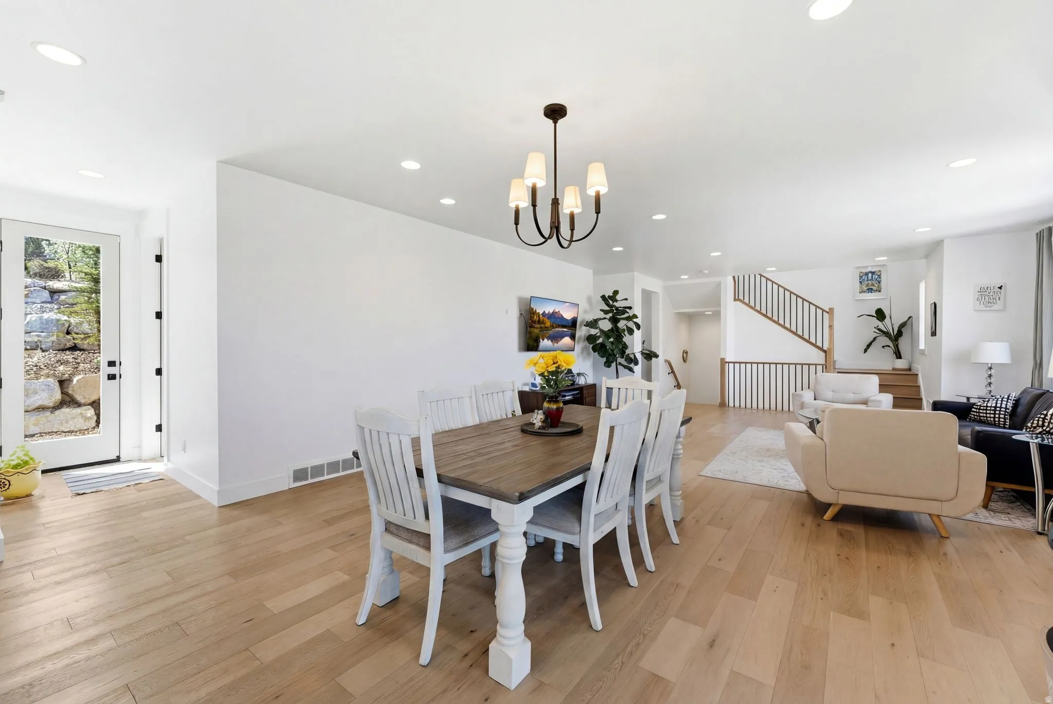 Dining room with light wood-type flooring and suspended lighting