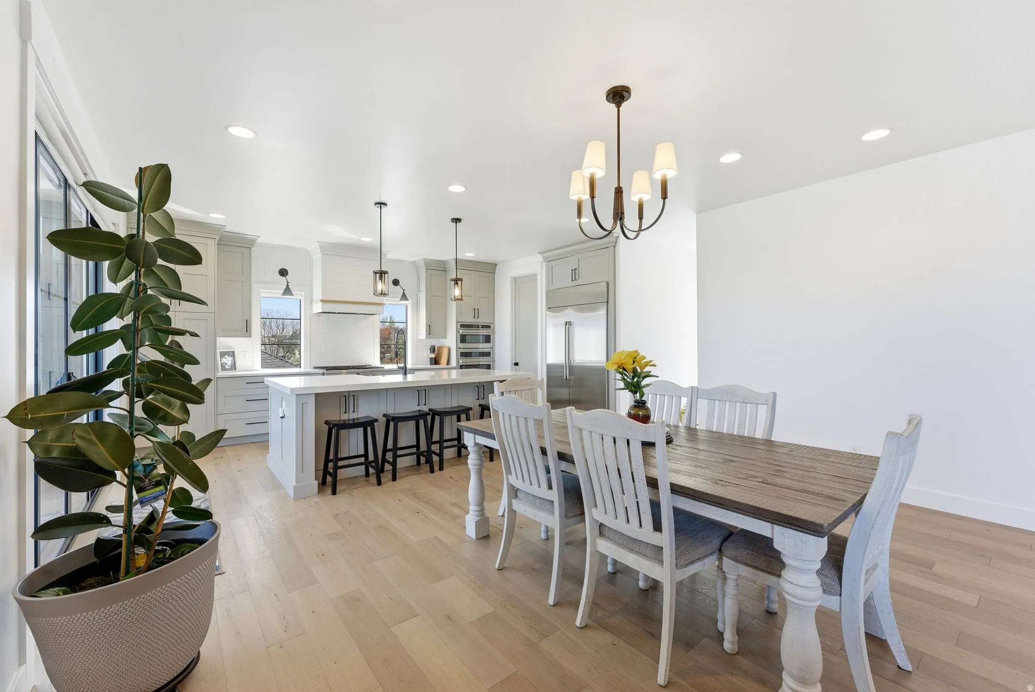 Dining space with light wood-style flooring and hanging lights
