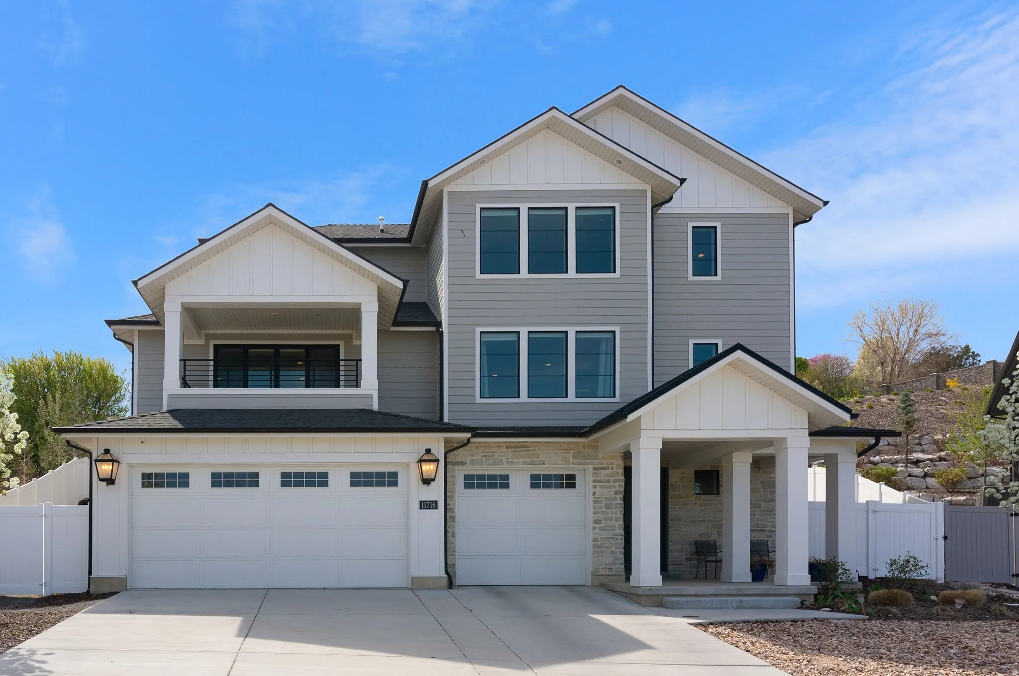View of front facade with board and batten siding, a gate, an attached garage, and concrete driveway