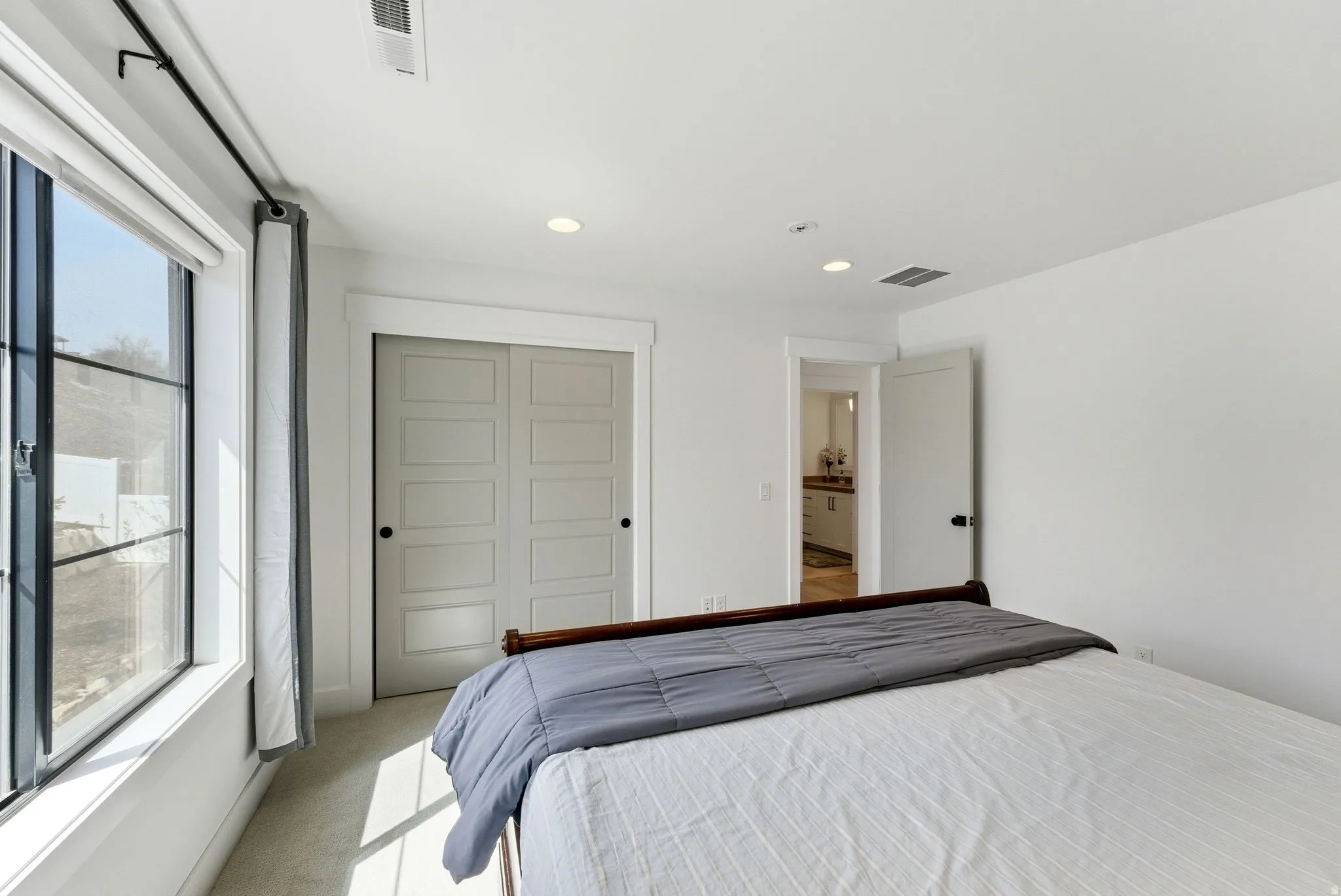 Bedroom with light colored carpet, a closet, and recessed lighting