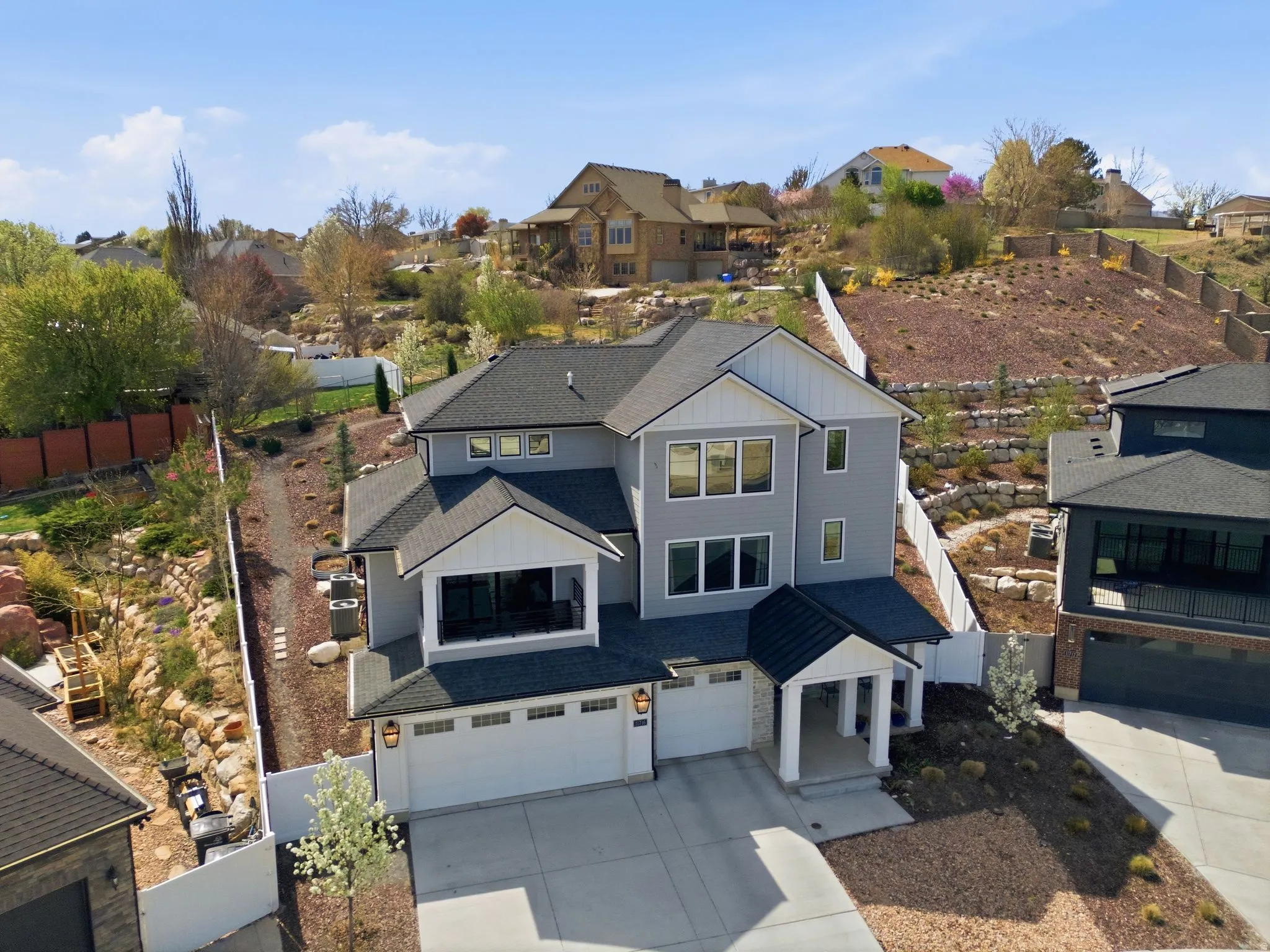 View of front of house featuring board and batten siding, an attached garage, a residential view, and concrete driveway