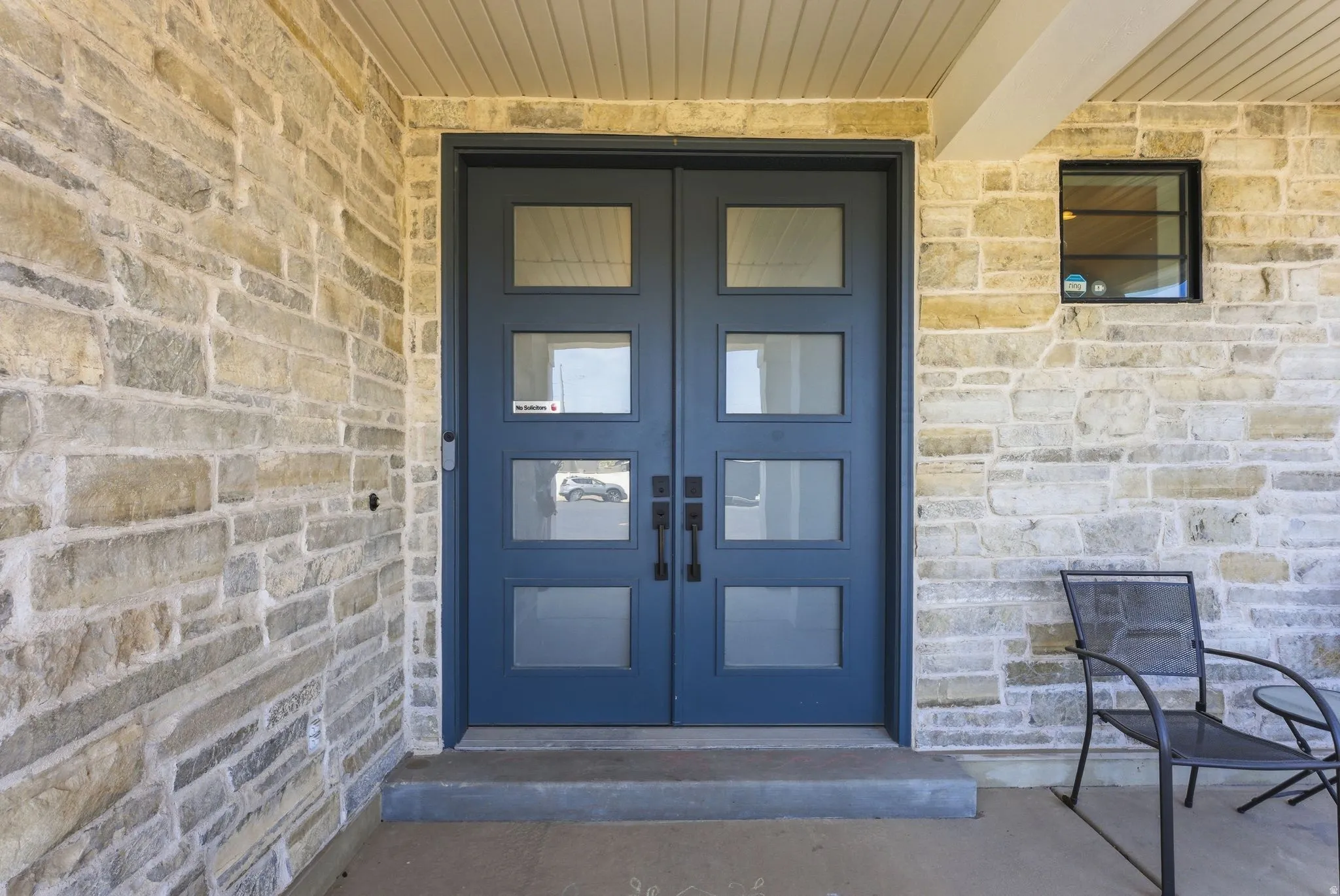 View of exterior entry featuring stone siding and french doors