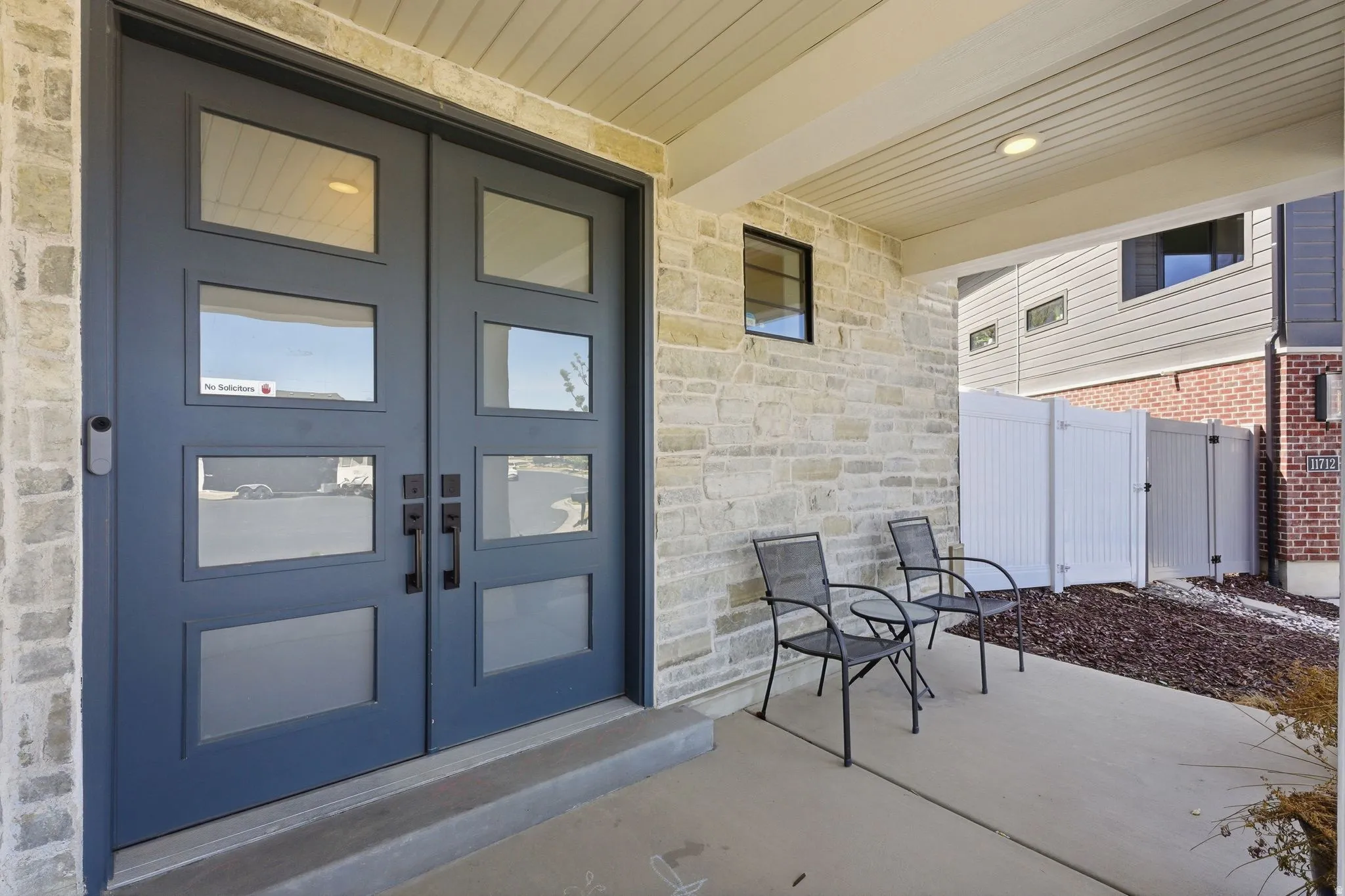 Property entrance featuring stone siding and a patio area