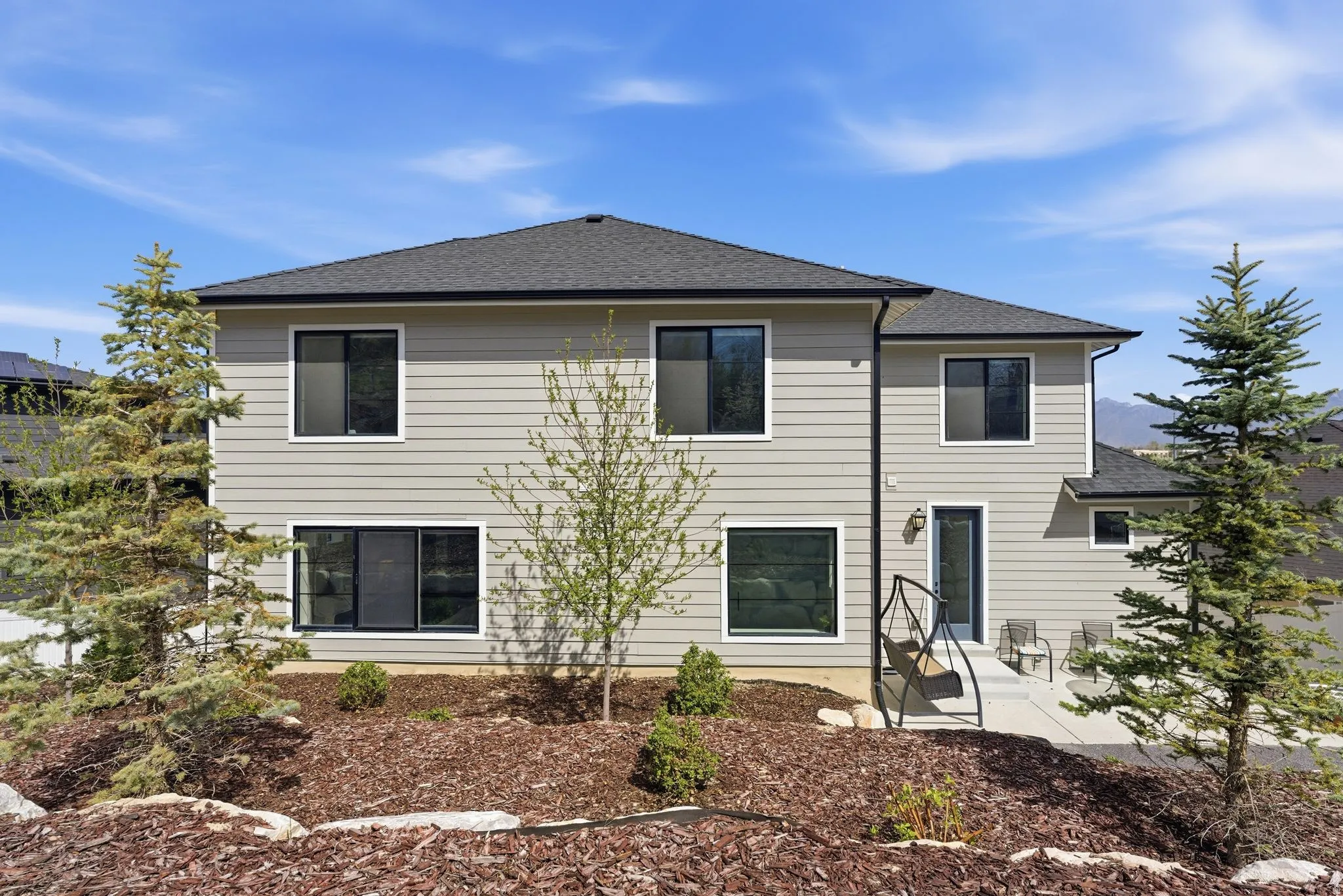 Rear view of property featuring roof with shingles and a patio area
