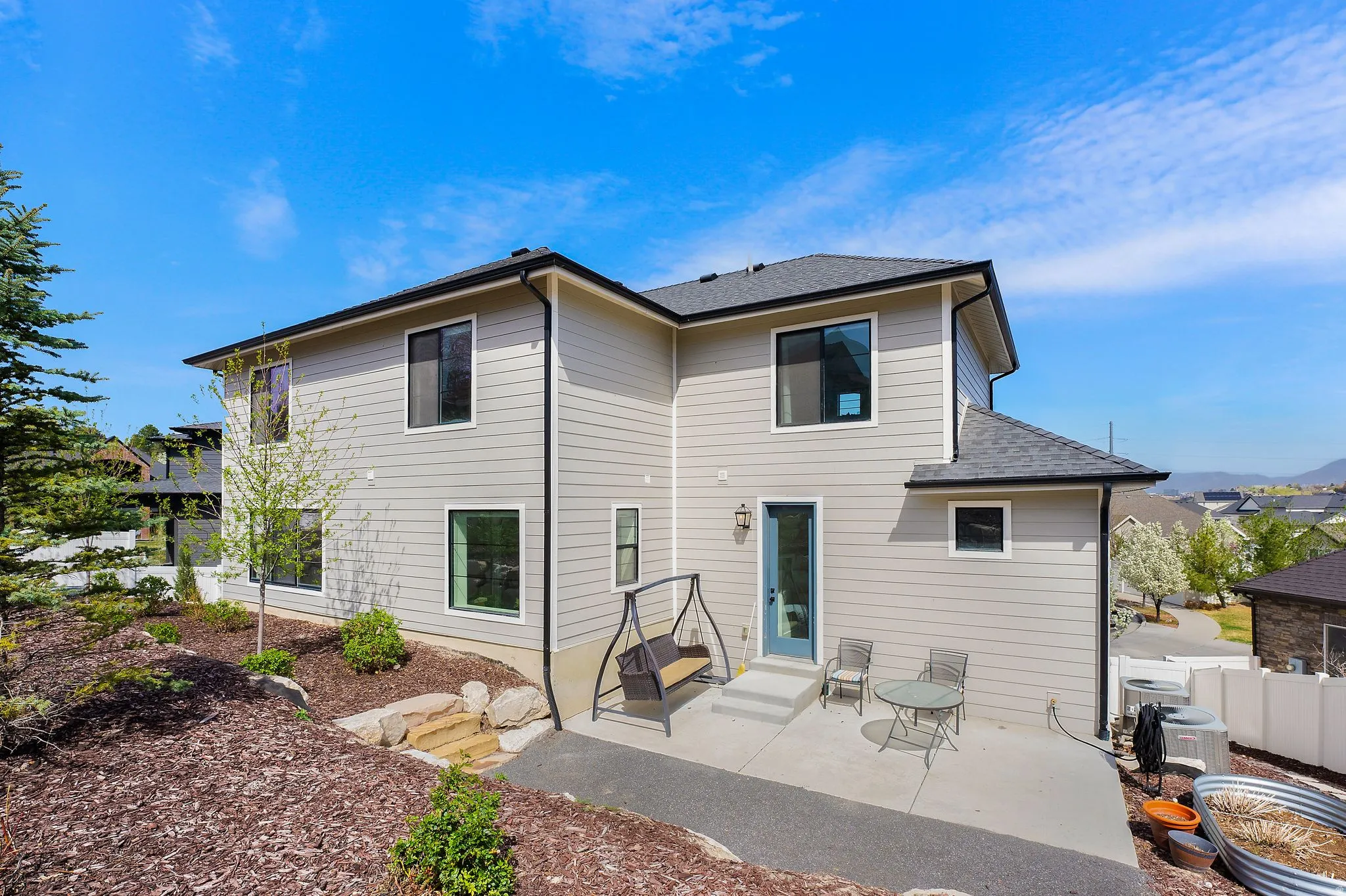 Rear view of house with a patio and a shingled roof