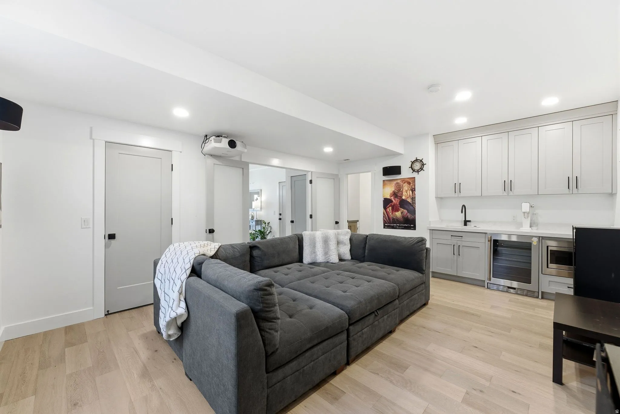 Living area with beverage cooler, wet bar, light wood-style flooring, and recessed lighting