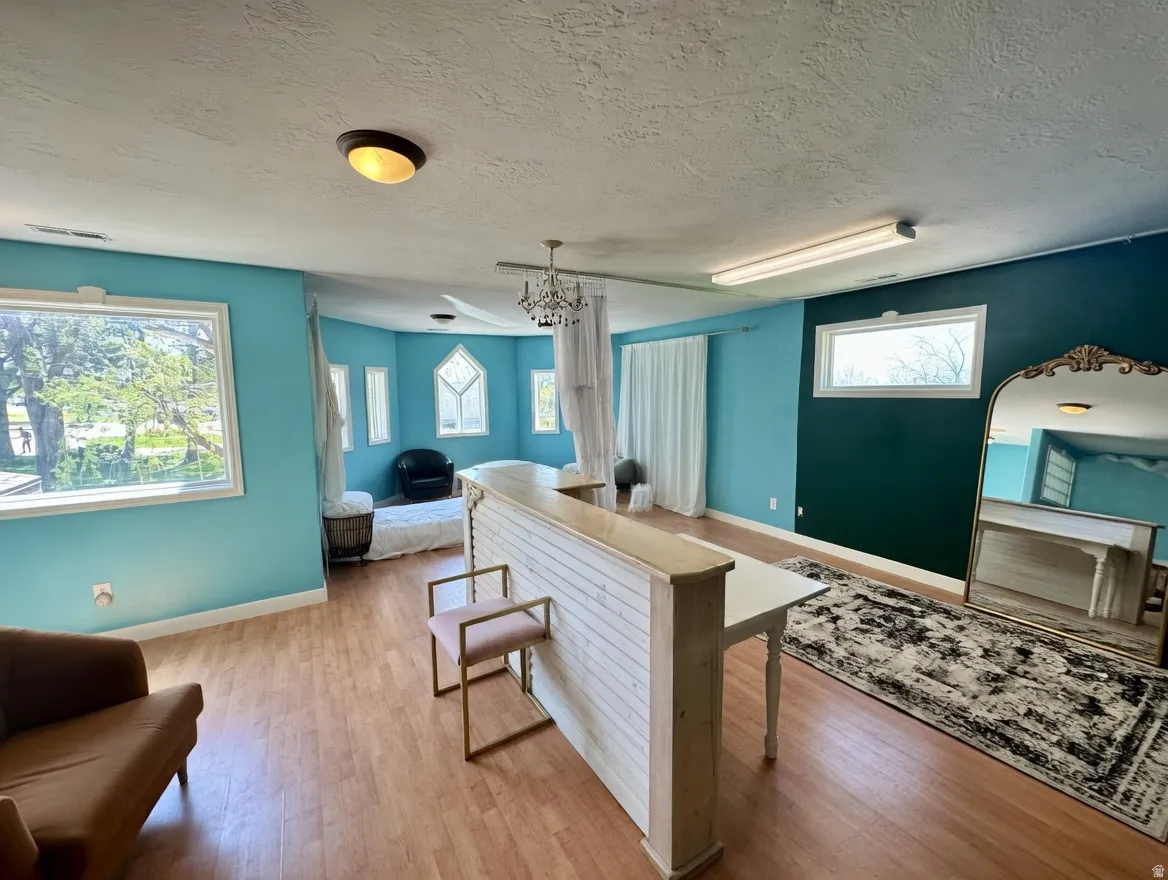 Kitchen featuring wood finished floors, a textured ceiling, healthy amount of natural light, and open floor plan