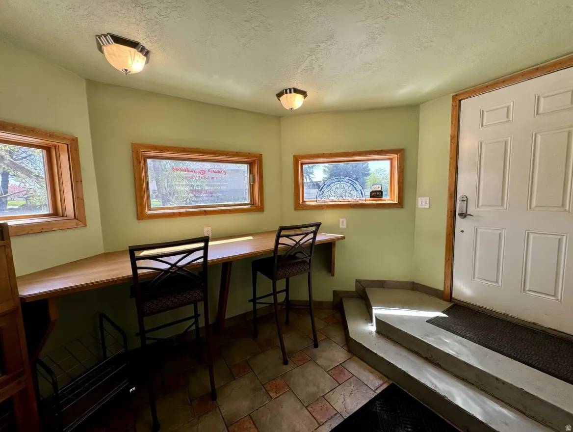Dining space featuring a textured ceiling and stone tile floors