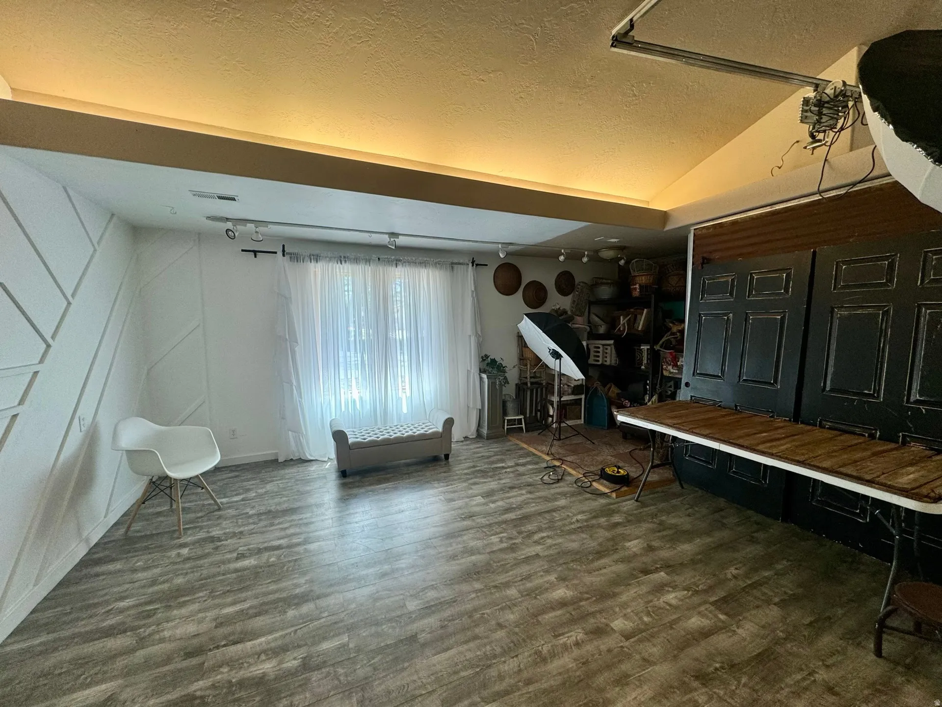 Below grade area featuring a textured ceiling, dark wood-style flooring, and a decorative wall