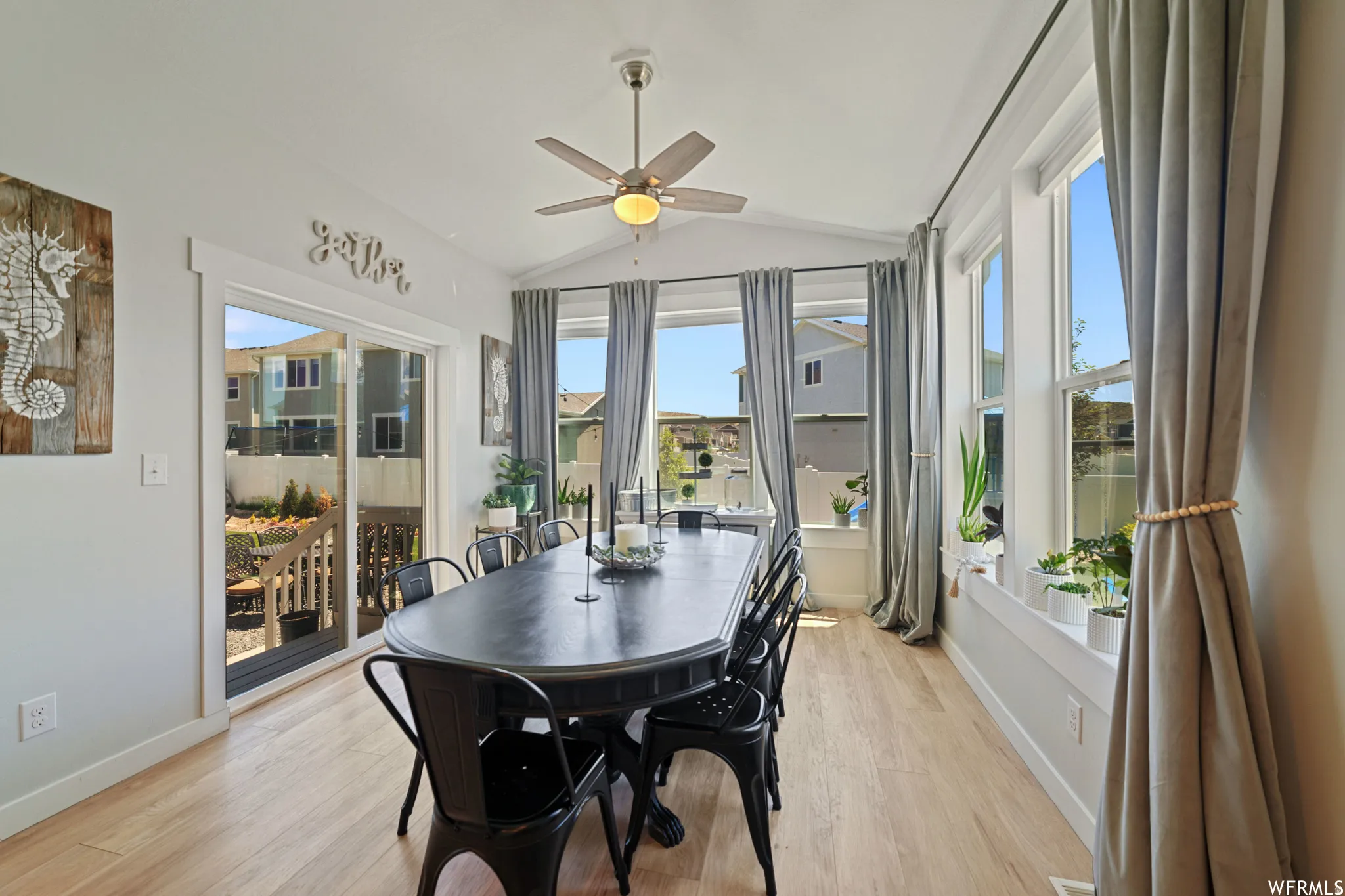 Dining room with vaulted ceiling, a ceiling fan, and light wood-type flooring