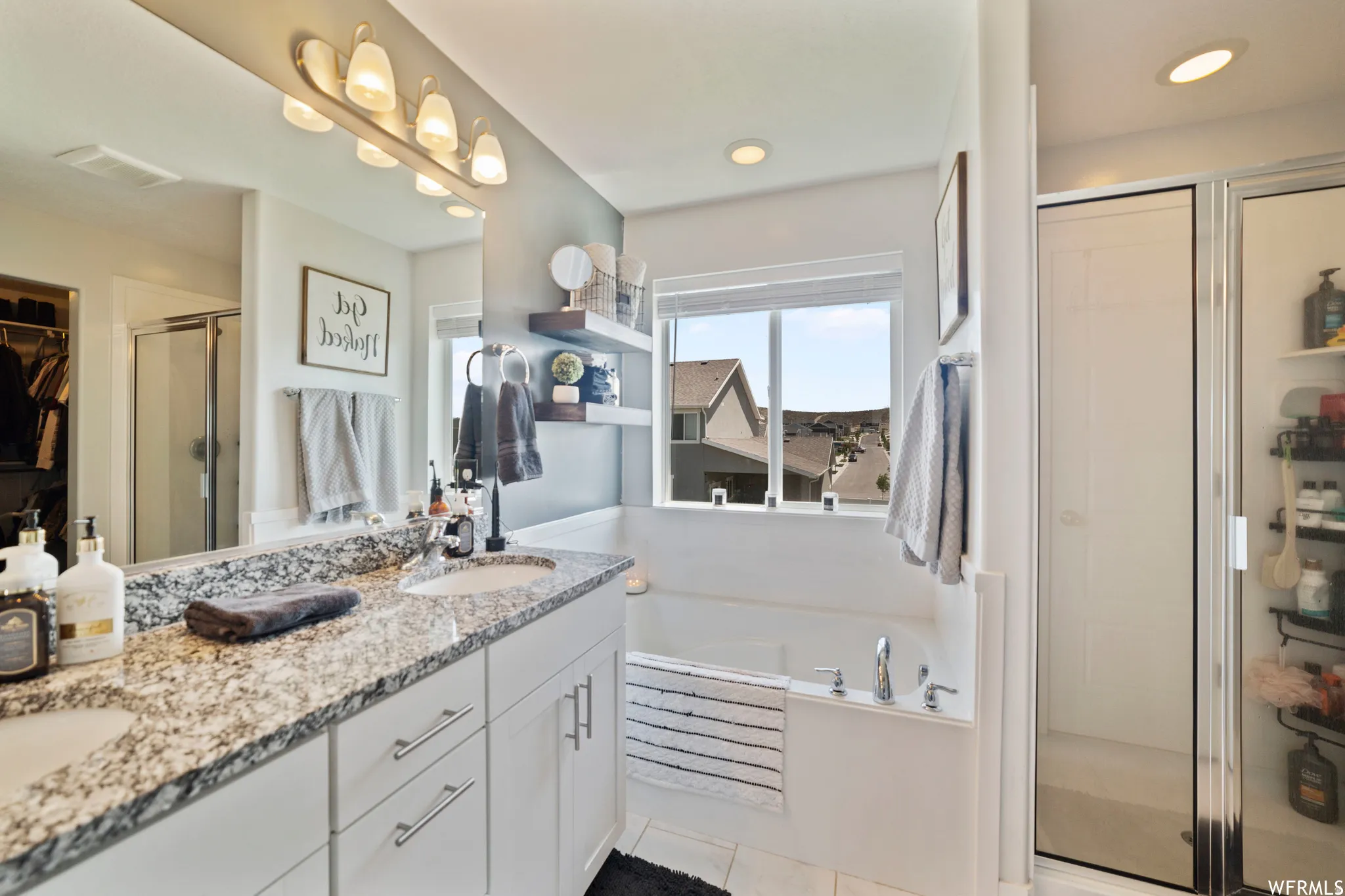 Full bath featuring a shower stall, a garden tub, double vanity, a spacious closet, and recessed lighting