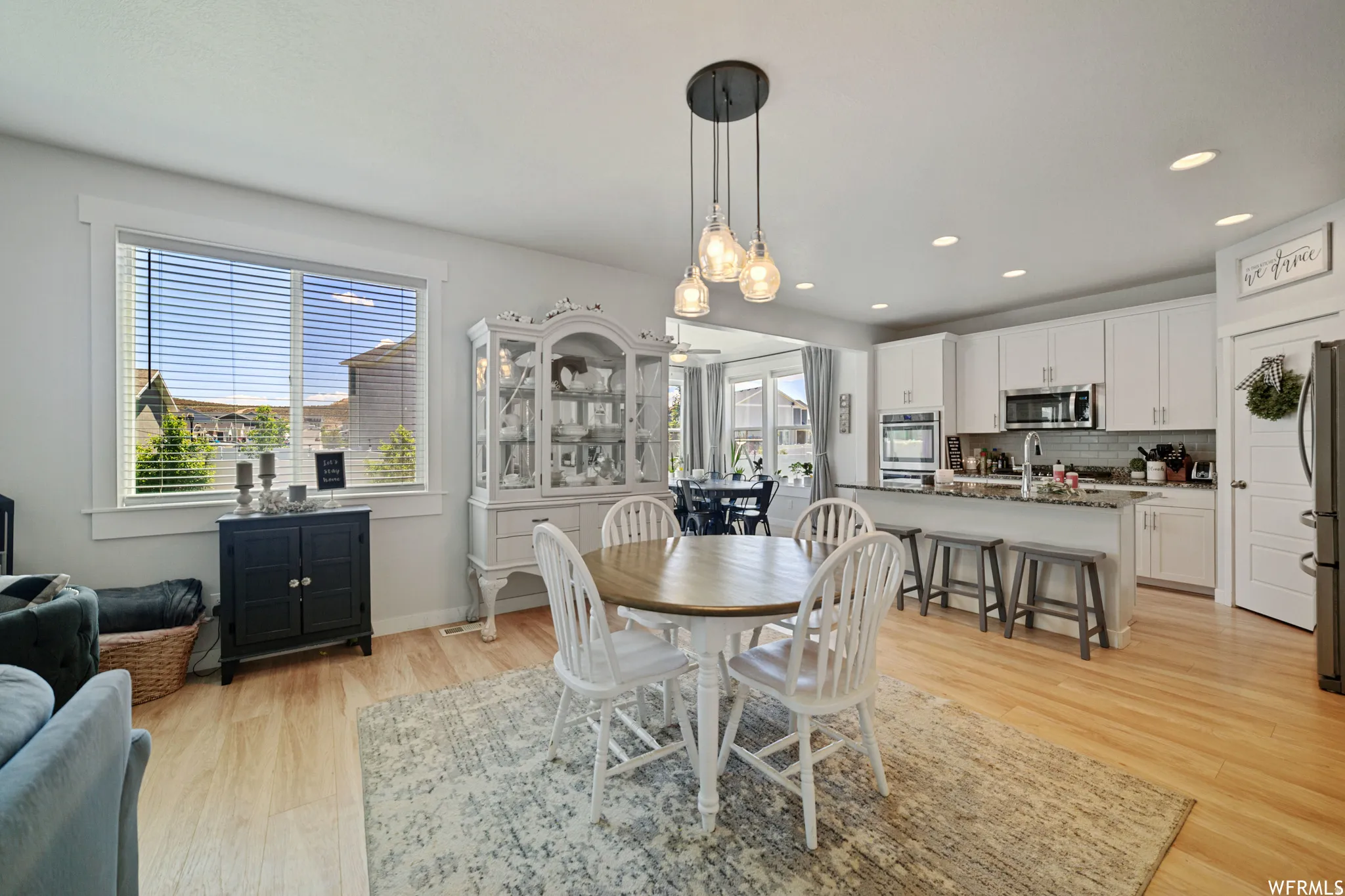 Dining space with light wood finished floors and recessed lighting