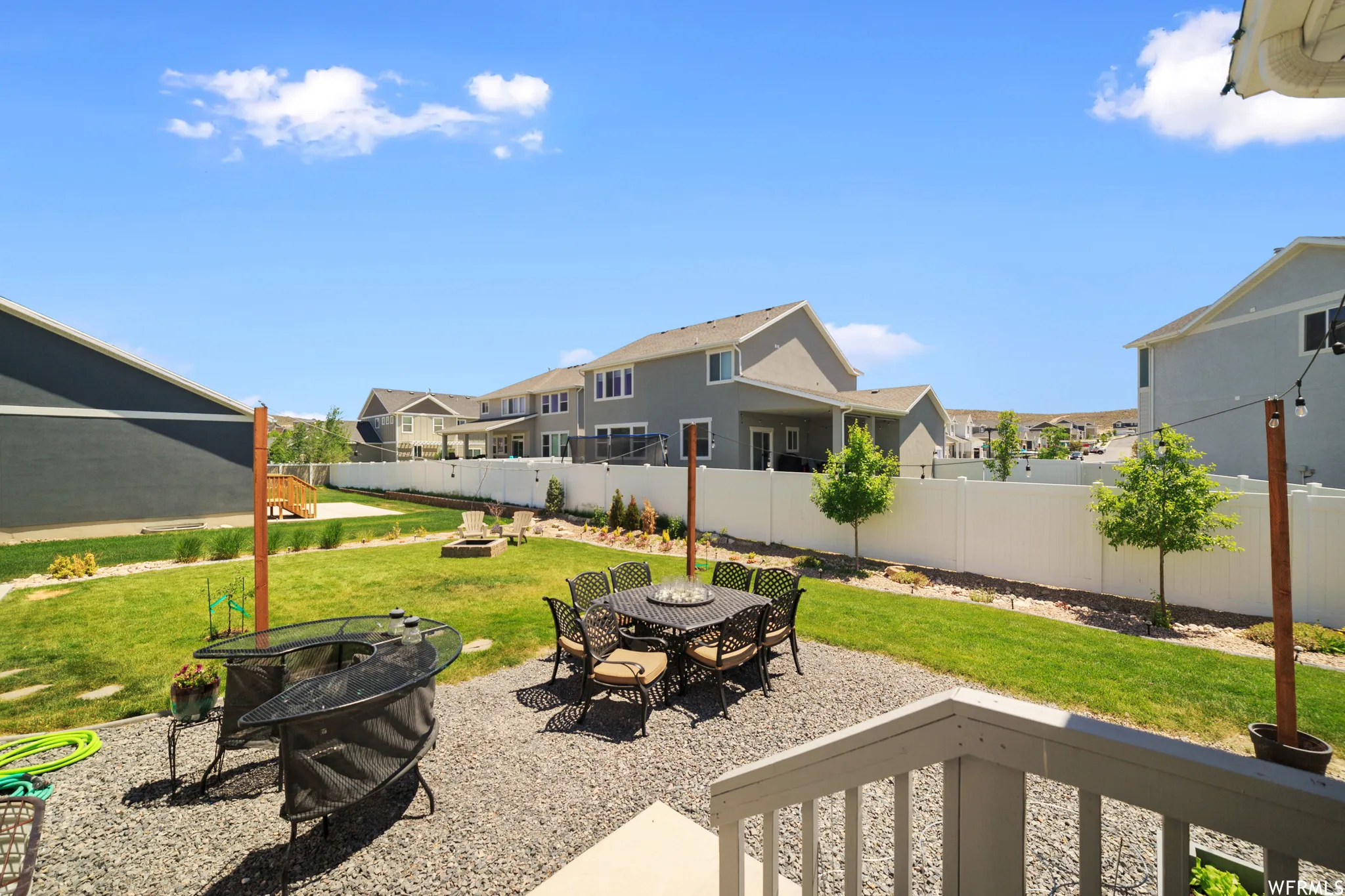 Fenced backyard with a patio area, an outdoor fire pit, a residential view, and outdoor dining space
