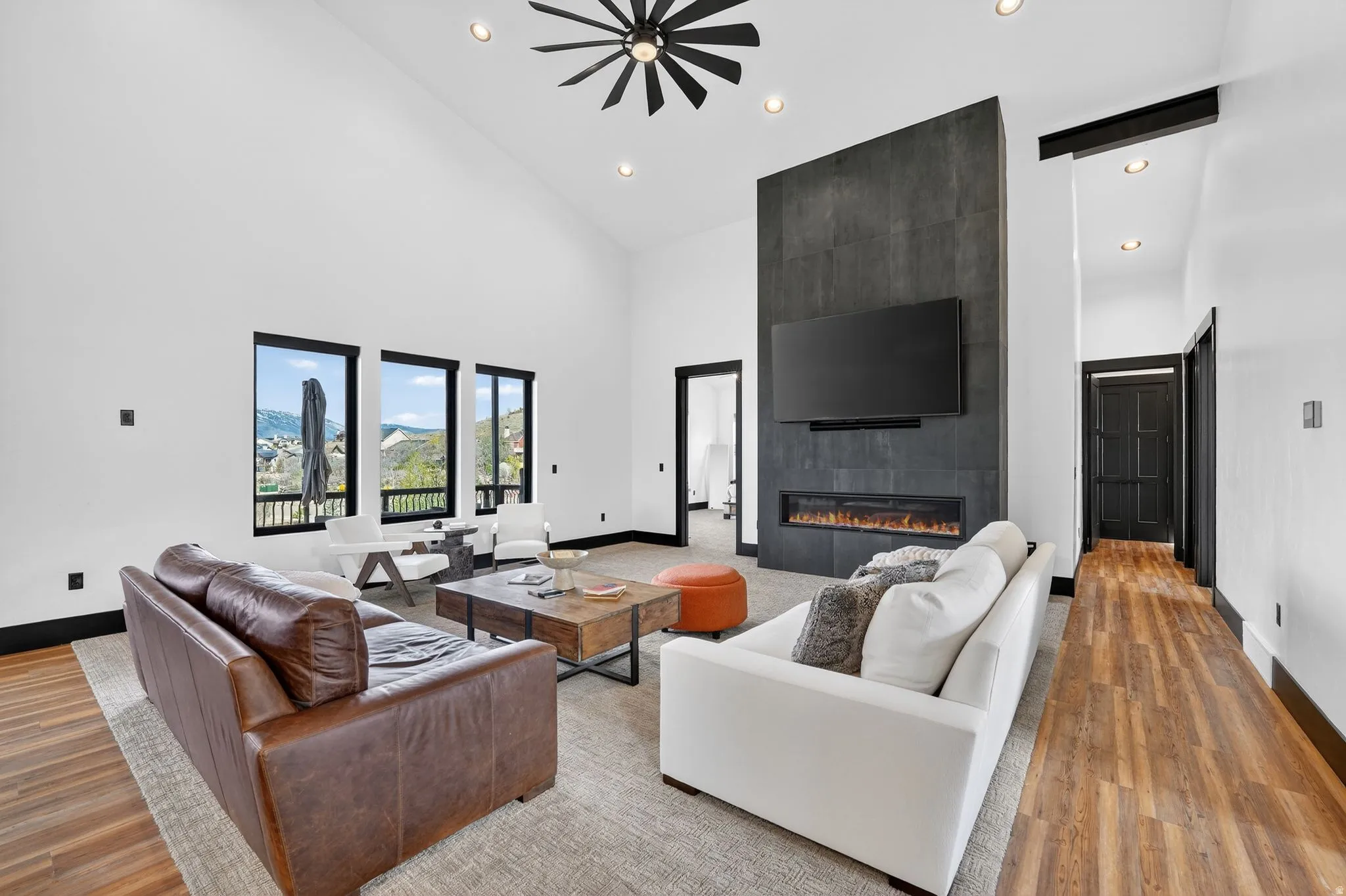 Living room with a fireplace, wood finished floors, ceiling fan, recessed lighting, and lofted ceiling