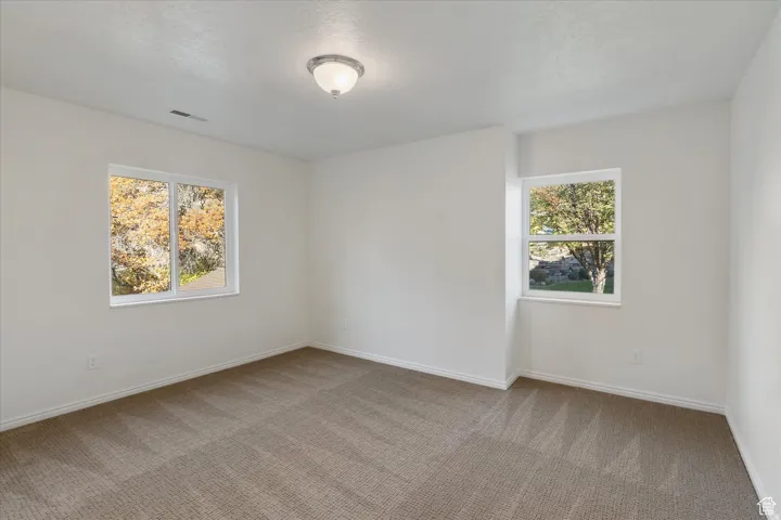 Empty room featuring carpet and baseboards
