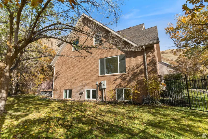 View of side of home featuring brick siding and a shingled roof