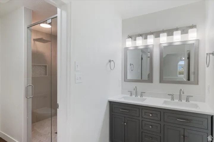 Bathroom featuring double vanity and a stall shower