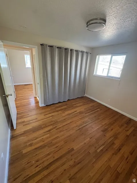 Spare room featuring wood finished floors and a textured ceiling