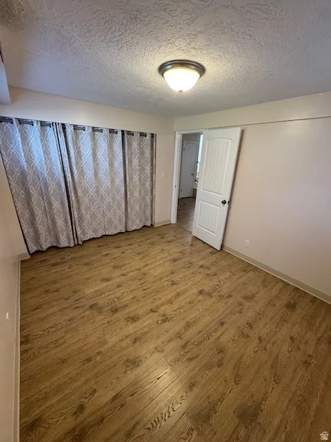 Spare room featuring wood finished floors and a textured ceiling