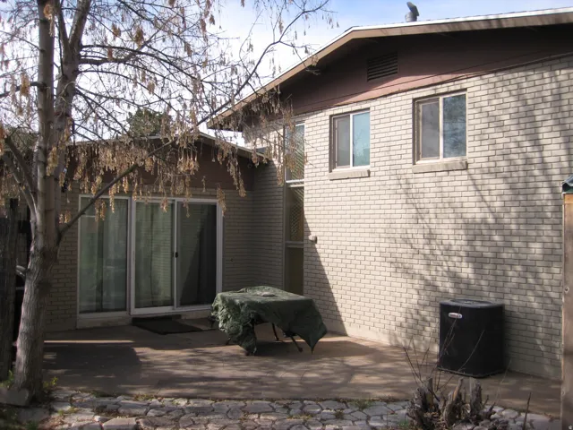 Back of house with brick siding and a patio area
