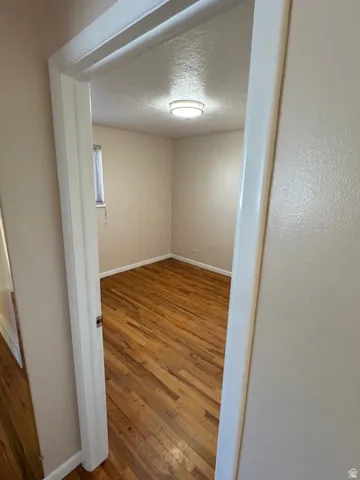 Unfurnished room with dark wood finished floors and a textured ceiling