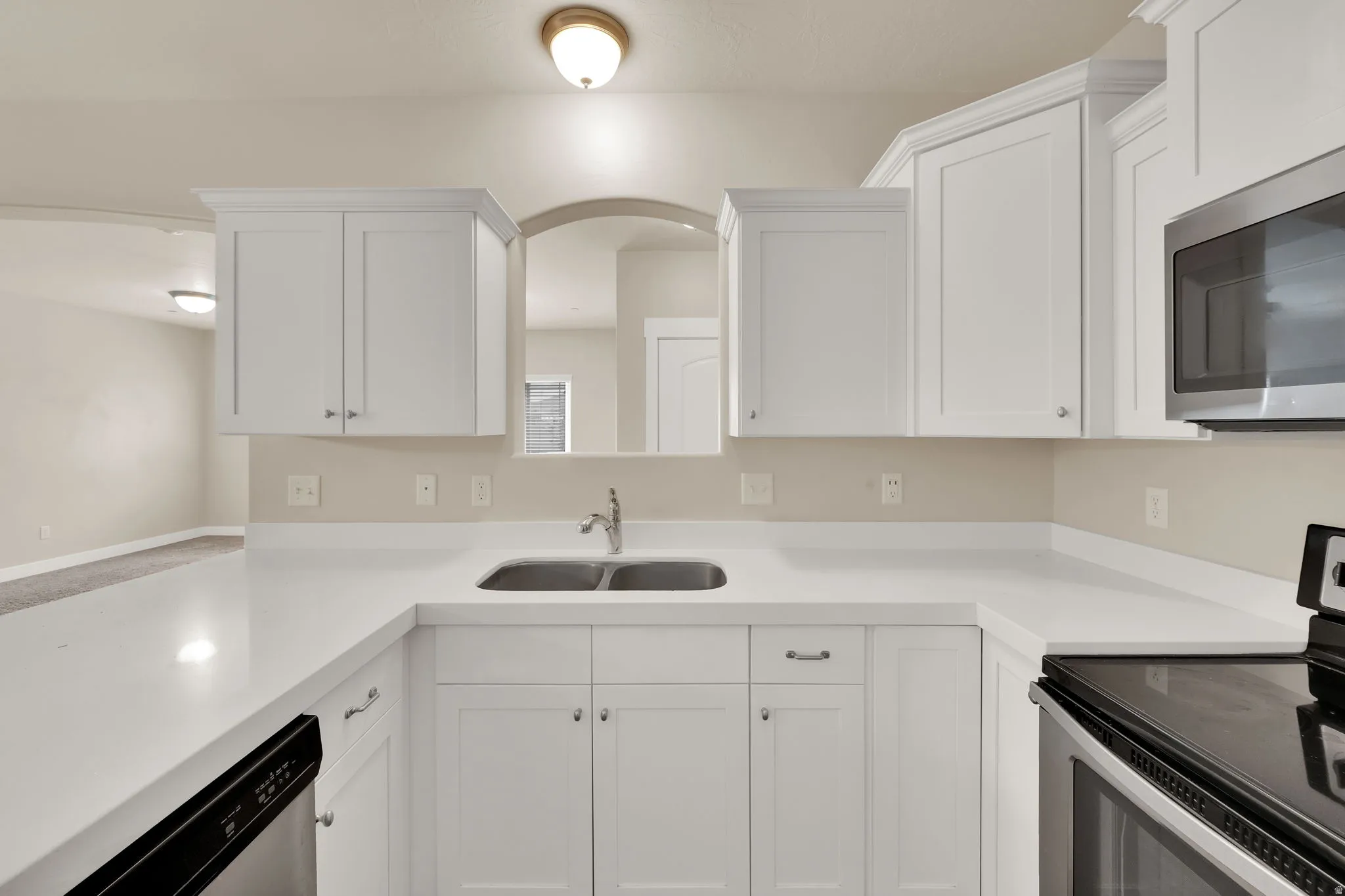 Kitchen featuring stainless steel appliances and white cabinetry
