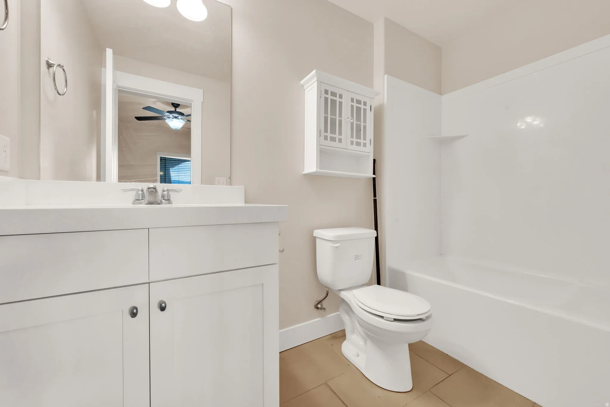 Full bath with vanity, light tile patterned flooring, bathing tub / shower combination, and a ceiling fan