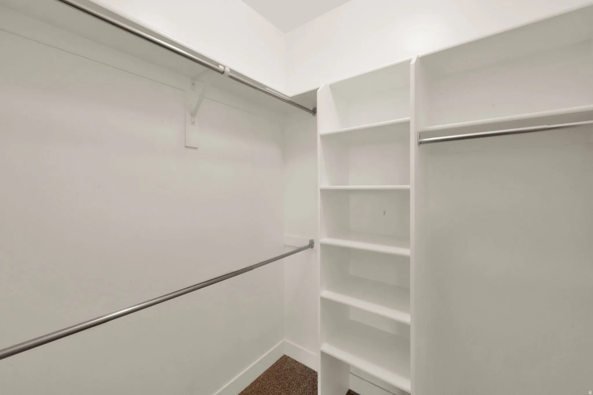 Walk in closet featuring dark colored carpet
