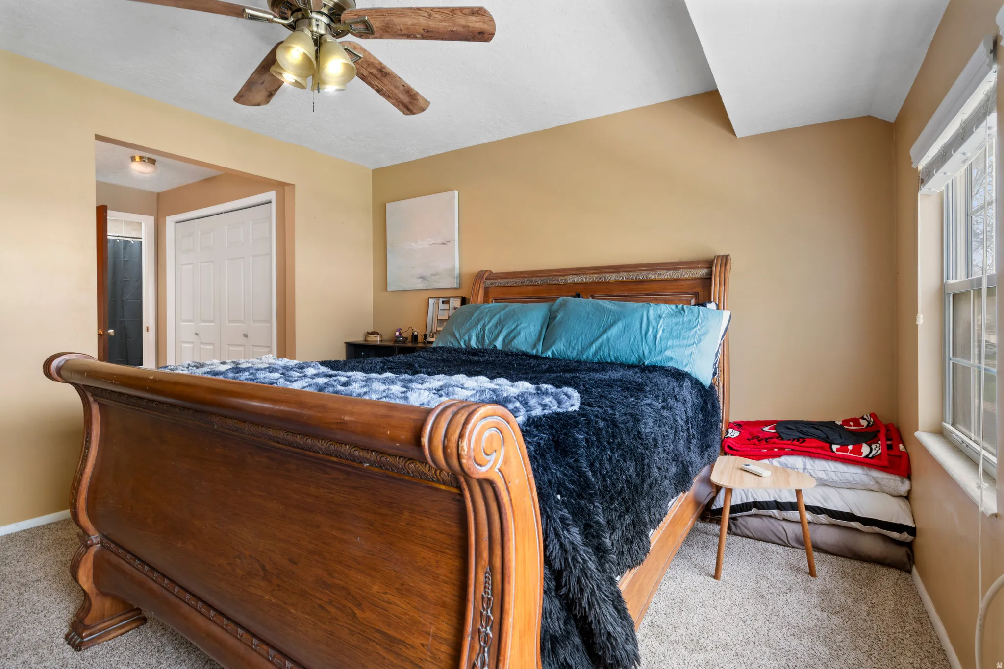 Bedroom with light carpet, a closet, and a ceiling fan