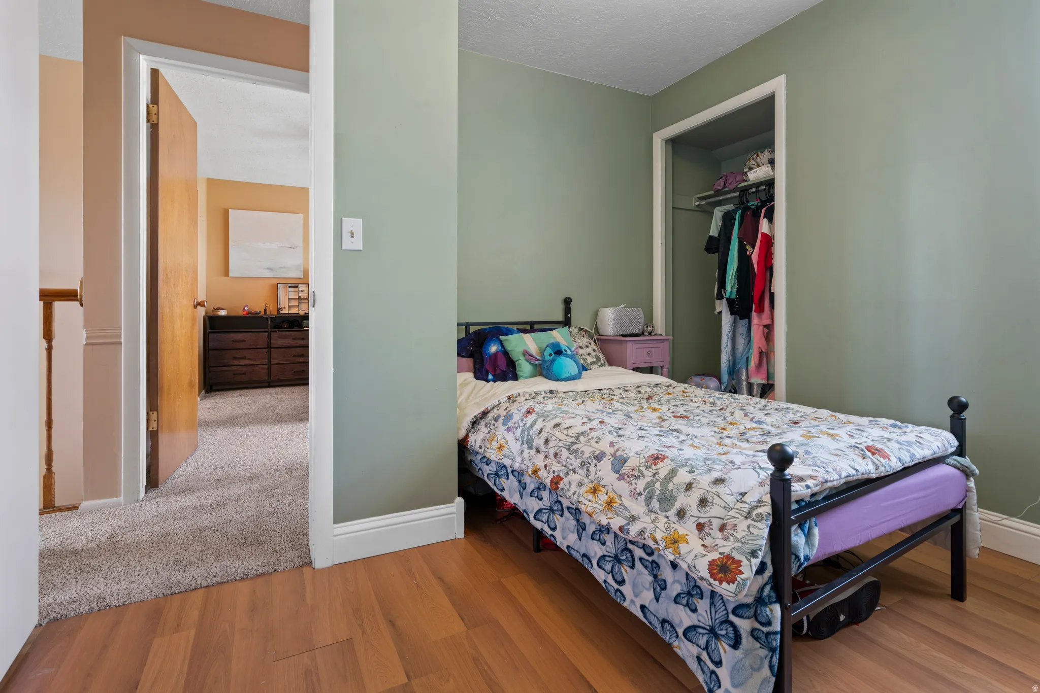 Bedroom featuring a closet, a textured ceiling, and light wood-style floors