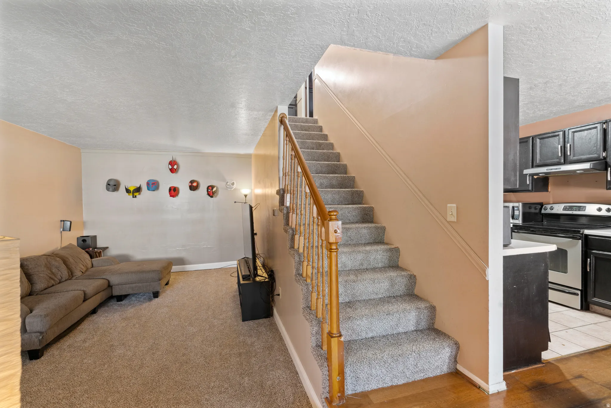 Stairway featuring a textured ceiling and baseboards
