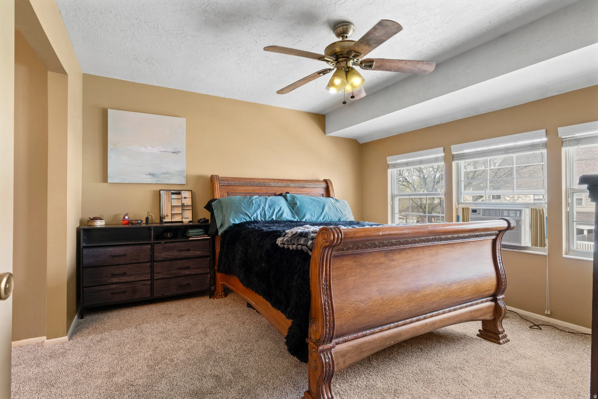 Bedroom featuring light colored carpet, a textured ceiling, ceiling fan, and cooling unit