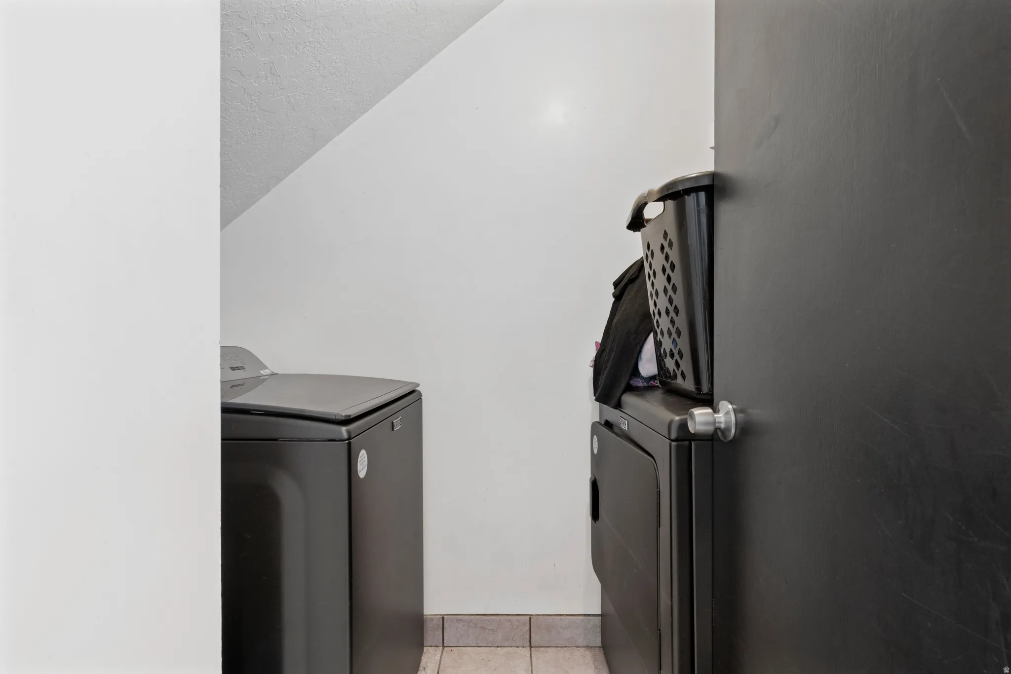 Laundry room featuring independent washer and dryer and light tile patterned floors