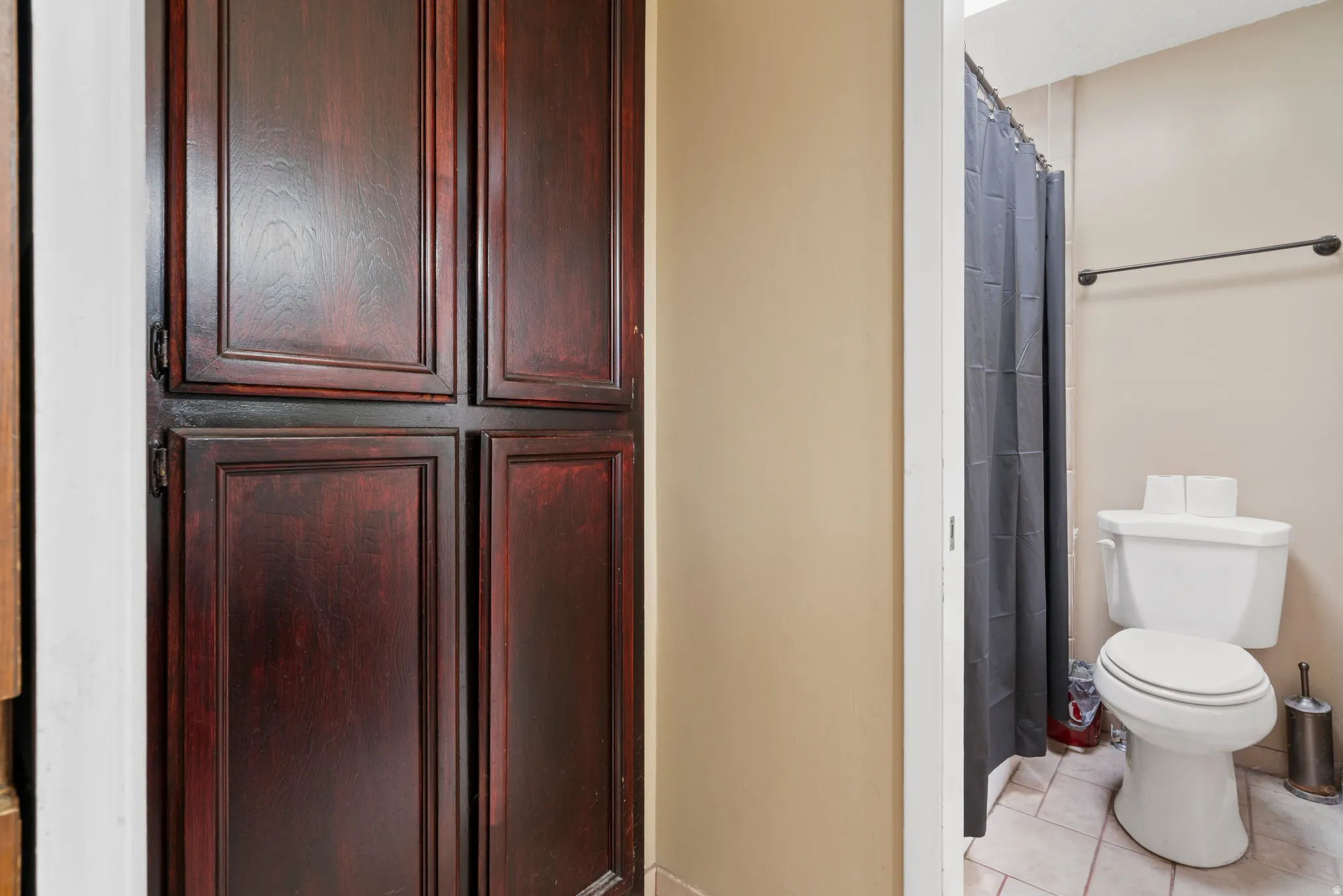 Full bath with curtained shower and light tile patterned floors