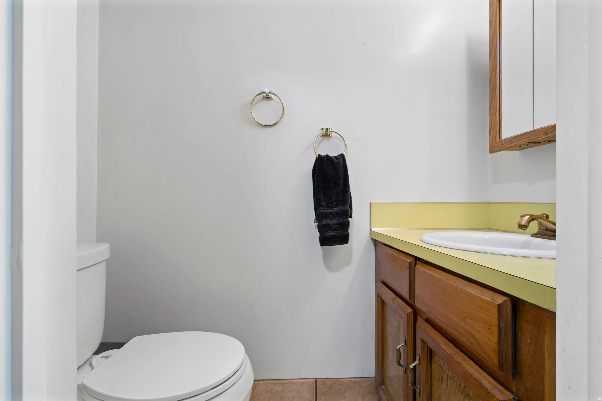 Half bath with vanity and light tile patterned floors
