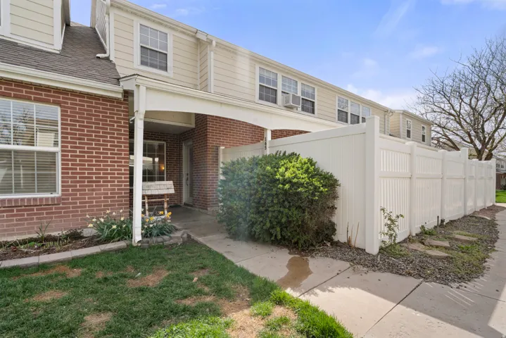 Doorway to property with brick siding and a shingled roof