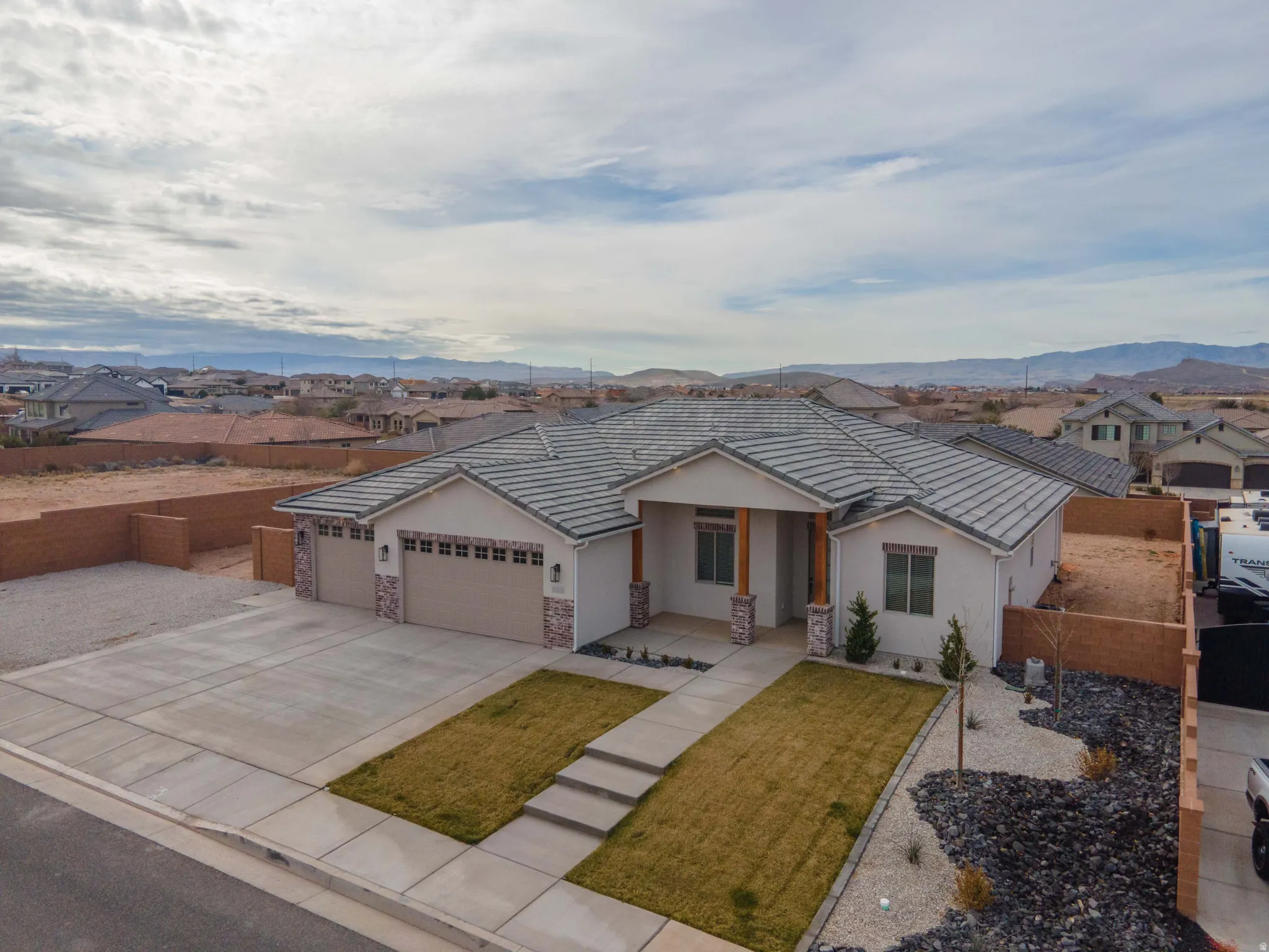Ranch-style house featuring a garage, driveway, a residential view, and stucco siding