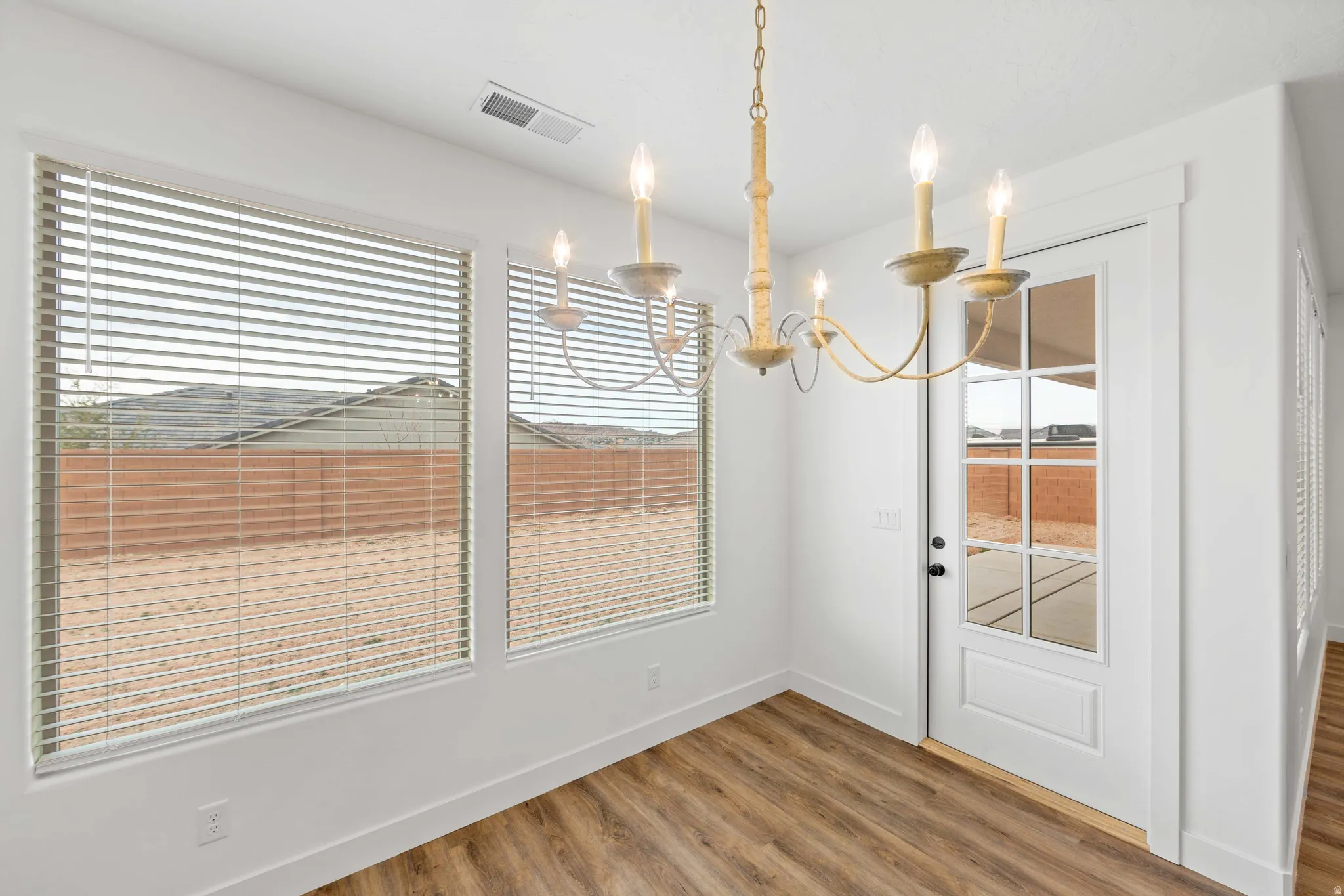 Unfurnished dining area featuring light wood-style floors and suspended lighting