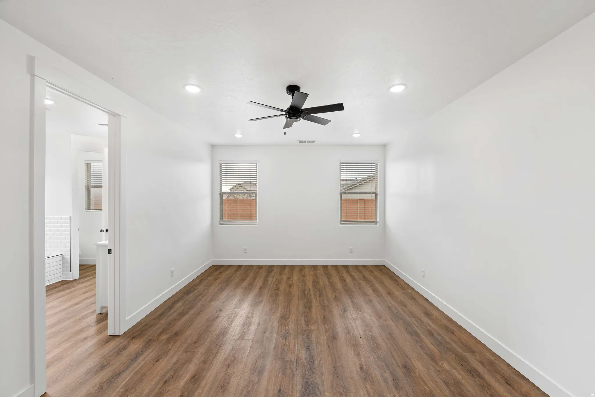 Spare room featuring dark wood-style floors, a ceiling fan, and recessed lighting