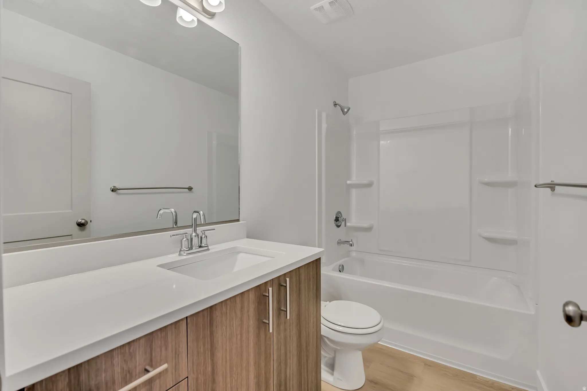 Bathroom featuring a vanity with a white countertop, under-mount sink, and wood-finish cabinetry