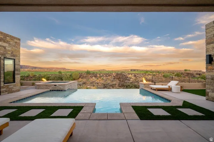 Integrated pool / hot tub featuring a patio and a fenced backyard