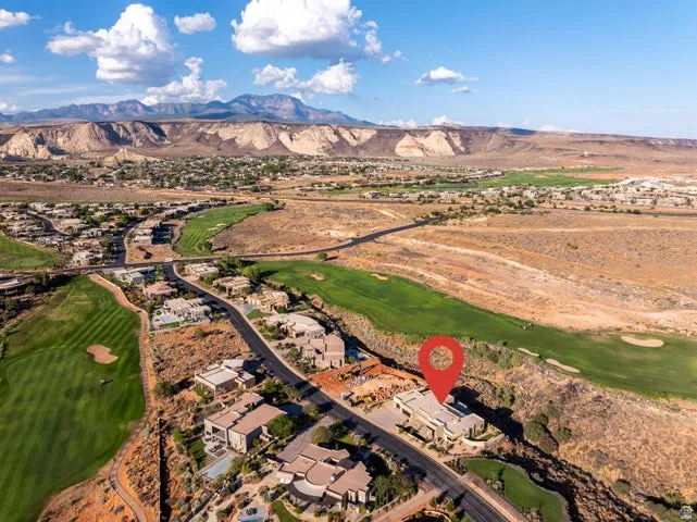 Aerial view of residential area with a golf club and mountains