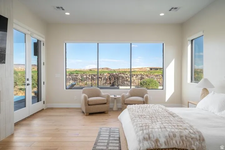 Bedroom with light wood-style floors, access to outside, recessed lighting, and french doors