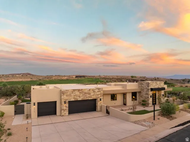 Adobe home featuring a patio, a garage, stucco siding, and concrete driveway