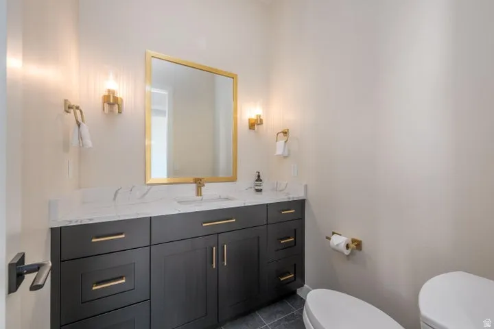 Half bathroom with vanity and dark tile patterned floors