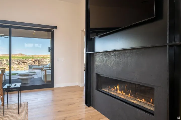 Detailed view of wood finished floors and a premium fireplace