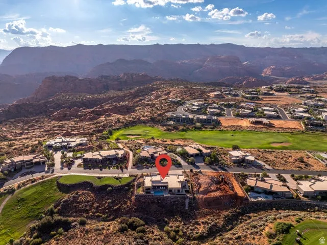 Aerial view of residential area with a golf club and a mountainous background
